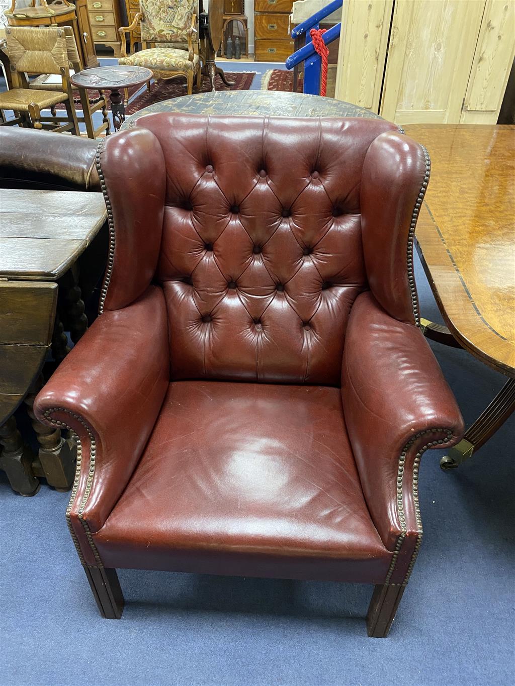 A pair of Chippendale-style buttoned leather wing armchairs, width 82cm, depth 72cm, height 94cm